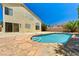 Backyard pool with stone surround, steps, and a house with a stucco exterior at 7521 Reindeer Ct, Las Vegas, NV 89147