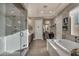 Bright and airy bathroom featuring a large soaking tub, a glass-enclosed shower, and dual vanities at 7670 Frittata Ave, Las Vegas, NV 89113