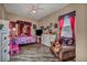 Cozy bedroom with a playful Minnie Mouse theme, wood floors and a comfortable reading chair at 7670 Frittata Ave, Las Vegas, NV 89113