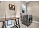 Well-equipped laundry room with a front-load washer/dryer, a folding table, and a bright window at 7670 Frittata Ave, Las Vegas, NV 89113