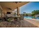 A covered patio with outdoor seating overlooking a refreshing pool with a waterfall feature at 7670 Frittata Ave, Las Vegas, NV 89113