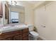 A bathroom features a vanity, a toilet, and a mirror at 7720 W Agate Ave, Las Vegas, NV 89113