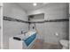 Modern bathroom featuring tiled walls, a whirlpool bathtub, and a separate toilet area at 7720 W Agate Ave, Las Vegas, NV 89113