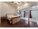 Well-lit bedroom with hardwood floors, ceiling fan, attached kitchen space and bright windows at 7720 W Agate Ave, Las Vegas, NV 89113