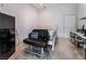 Cozy bedroom with tiled floors and an accent chair, plus small fridge and storage at 7720 W Agate Ave, Las Vegas, NV 89113
