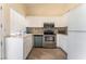 A bright kitchen features white cabinetry, stainless steel appliances, and tile flooring at 7720 W Agate Ave, Las Vegas, NV 89113