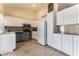 A bright kitchen features white cabinets, stainless steel appliances, and tile flooring at 7720 W Agate Ave, Las Vegas, NV 89113