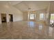 Expansive living room with vaulted ceilings and light tile floors, adjacent bedroom and arched window features at 7720 W Agate Ave, Las Vegas, NV 89113