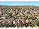 Expansive aerial view of a vibrant community with beautiful homes, lush landscaping, and stunning mountain backdrop at 8083 Shadowvale Dr, Las Vegas, NV 89147