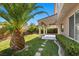 Lush backyard with manicured lawn, mature landscaping, stone paver pathway, and a covered patio at 8083 Shadowvale Dr, Las Vegas, NV 89147