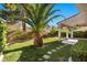 Lush backyard featuring mature landscaping, a well-maintained lawn, and a stepping stone pathway at 8083 Shadowvale Dr, Las Vegas, NV 89147