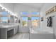 Inviting bathroom with double vanity, a soaking tub, and a large window offering natural light at 8083 Shadowvale Dr, Las Vegas, NV 89147
