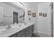 Clean bathroom with a double sink vanity, granite countertop, decorative mirrors, and neutral decor at 8083 Shadowvale Dr, Las Vegas, NV 89147