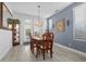 Traditional dining room featuring an elegant chandelier, stylish mirror, and exterior views at 8083 Shadowvale Dr, Las Vegas, NV 89147