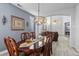 Large dining room with bright lighting, luxury chandelier, and views into the living room at 8083 Shadowvale Dr, Las Vegas, NV 89147