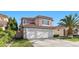 Charming two-story home boasts a three car garage, red tile roof, and lush landscaping at 8083 Shadowvale Dr, Las Vegas, NV 89147