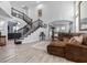 Open-concept living room features a grand staircase, plush seating, and wood flooring at 8083 Shadowvale Dr, Las Vegas, NV 89147