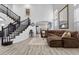 Open-concept living room features a grand staircase, plush seating, and wood flooring at 8083 Shadowvale Dr, Las Vegas, NV 89147