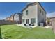 This backyard features artificial grass, a seating area, a grill, and an AC unit at 8254 Palladium St, Las Vegas, NV 89113