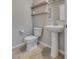 Powder room with pedestal sink, modern fixtures, and decorative shelving at 8254 Palladium St, Las Vegas, NV 89113