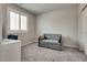 Neutral bedroom with a blue loveseat and a window with white shutters at 8254 Palladium St, Las Vegas, NV 89113