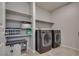This laundry room has a front loading washer and dryer, storage cabinets, and shelves at 8254 Palladium St, Las Vegas, NV 89113