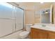 Bathroom featuring a vanity, toilet, and a shower-tub combination with sliding glass doors at 8448 Quarentina Ave, Las Vegas, NV 89149