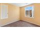 Cozy bedroom featuring neutral walls and carpet with natural light from a bright window at 8448 Quarentina Ave, Las Vegas, NV 89149