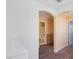 Hallway with neutral paint and carpet leading to an arched entryway and view of a bathroom at 8448 Quarentina Ave, Las Vegas, NV 89149