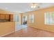 The sunny living room with wood floors leads into the kitchen, which offers backyard views at 8448 Quarentina Ave, Las Vegas, NV 89149
