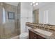 Bathroom showcasing a glass-enclosed shower, decorative tile work, a dark wood vanity, and modern fixtures at 8825 Rozetta Ct, Las Vegas, NV 89134
