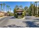 Gated community entrance with lush landscaping, stone pillars, and a security booth for added privacy at 8825 Rozetta Ct, Las Vegas, NV 89134