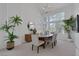 Bright dining room with modern chandelier, tall ceilings, large windows, and decorative plants at 8825 Rozetta Ct, Las Vegas, NV 89134