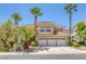 Elegant two-story home with a tile roof, three-car garage, balcony, and mature palm tree landscaping at 8825 Rozetta Ct, Las Vegas, NV 89134