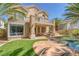 Exterior view of home features a second-story balcony, desert landscaping, and a private backyard oasis at 8825 Rozetta Ct, Las Vegas, NV 89134
