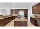 Spacious kitchen features an island, stainless steel appliances, granite countertops, and custom wood cabinetry at 8825 Rozetta Ct, Las Vegas, NV 89134