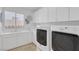 Well-lit laundry room with sink, storage cabinets, and modern washer and dryer at 8825 Rozetta Ct, Las Vegas, NV 89134