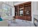 Cozy living room with a fireplace, built-in bookshelves with ladder, and large window with shutters at 8825 Rozetta Ct, Las Vegas, NV 89134