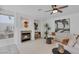 Comfortable living room with a fireplace, modern ceiling fan, and neutral color palette at 8825 Rozetta Ct, Las Vegas, NV 89134