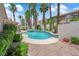 Inviting backyard with a beautiful pool, lush greenery, and privacy wall at 9500 Catalina Cove Cir, Las Vegas, NV 89147