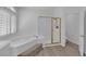 Bathroom featuring a separate shower and soaking tub with a large shuttered window at 9500 Catalina Cove Cir, Las Vegas, NV 89147