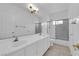 Bright bathroom featuring double sinks, tile floors, framed mirror, and glass shower enclosure at 9500 Catalina Cove Cir, Las Vegas, NV 89147