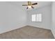 Bright bedroom with neutral carpet, white walls, ceiling fan and plantation shutters at 9500 Catalina Cove Cir, Las Vegas, NV 89147