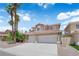 Charming two-story home with a well-manicured lawn, palm trees, and a three car garage at 9500 Catalina Cove Cir, Las Vegas, NV 89147