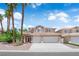 Charming two-story home with a well-manicured lawn, palm trees, and a three car garage at 9500 Catalina Cove Cir, Las Vegas, NV 89147