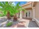 Well-manicured front yard with lush palm trees and a charming walkway to the front door at 9500 Catalina Cove Cir, Las Vegas, NV 89147