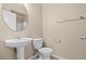 Bright bathroom featuring a pedestal sink, toilet, and towel rack at 9709 Fast Elk St, Las Vegas, NV 89143