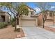 Exterior view of a two-story house with a two-car garage and desert landscaping at 9709 Fast Elk St, Las Vegas, NV 89143