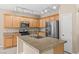 Modern kitchen features granite countertops, stainless steel appliances, and a large island with sink and plenty of cabinet space at 9709 Fast Elk St, Las Vegas, NV 89143