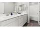 Bright bathroom with double sinks, white cabinetry, and neutral wall and floor coverings at 10776 Maltese Falcon Ave, Las Vegas, NV 89129